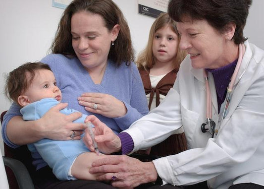newborn baby and a doctor giving a shot