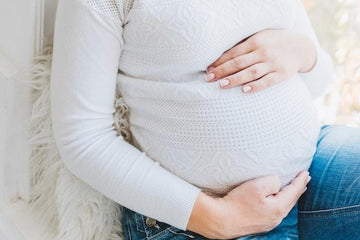 pregnant woman with white clothes and a pair of jeans