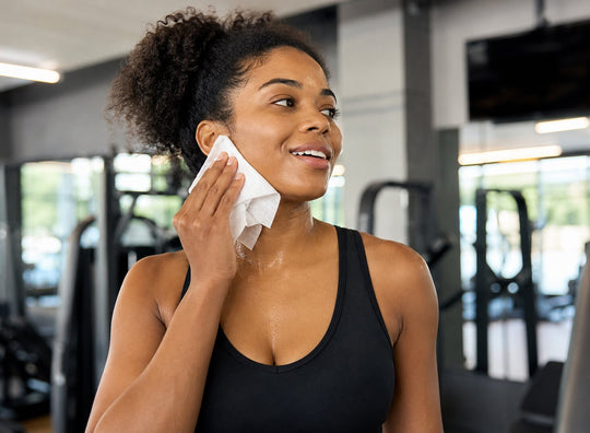 A woman refreshing her face with a wipe after exercise